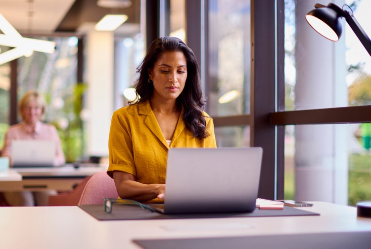 A woman discovers how long to keep invoices using a laptop computer.