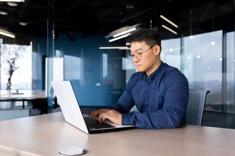 A man uses his laptop to sort through documents that need to be notarized.