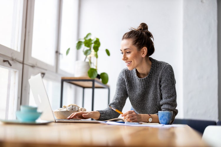 A woman reviews how to add a signature to Google Docs using a laptop.