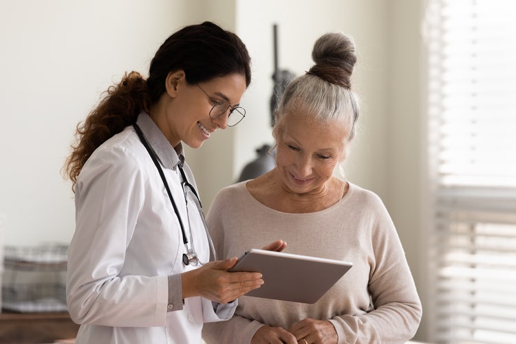 A woman uses a digital patient engagement platform on her tablet.