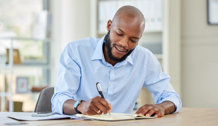 A man signing a document following CMS signature requirements.