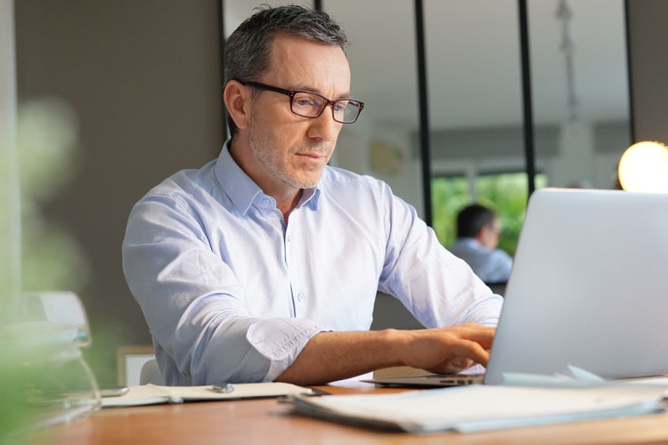 A man writes a staffing agency contract template on his computer