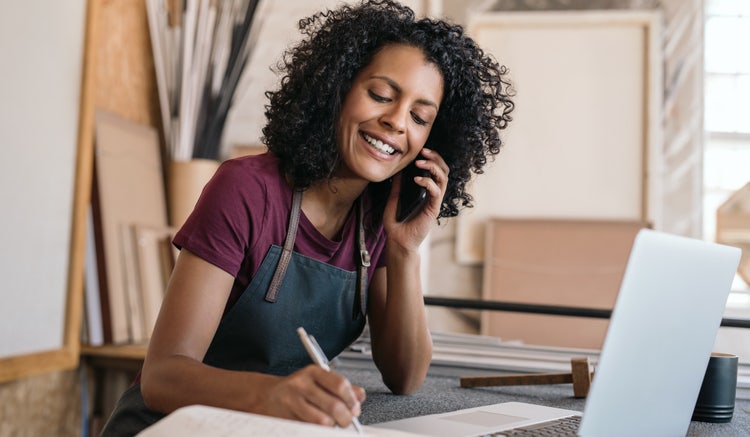 A micro-entrepreneur talks on a mobile phone during a client business call.