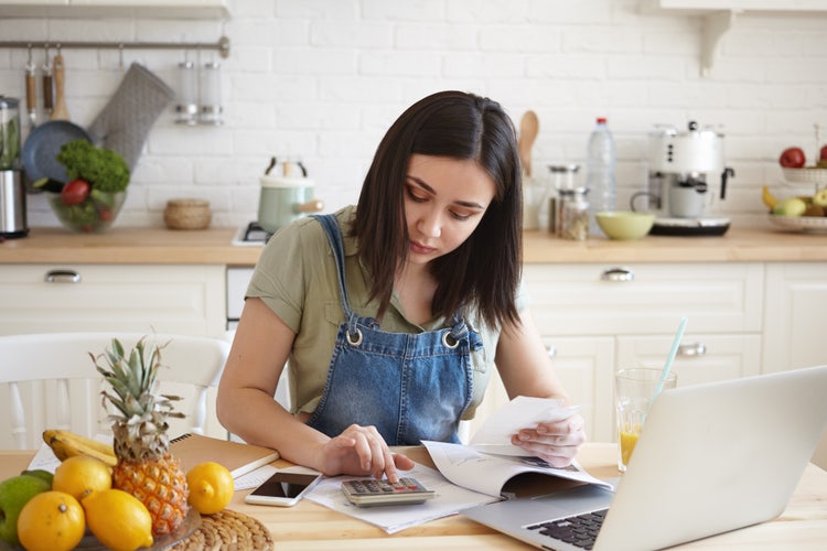 A business owner calculating their debit notes and credit notes accumulated by the business in preparation for tax season.