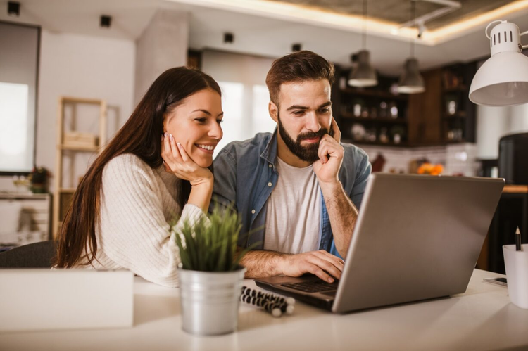 A husband and wife sign a buyer-broker agreement on their laptop.