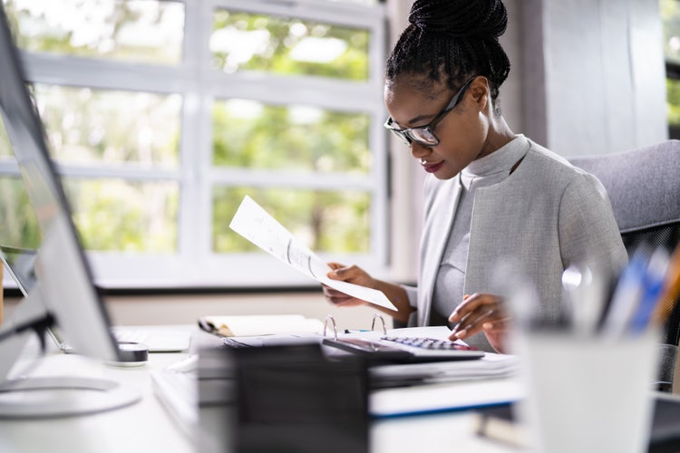 A young black woman works in a light-filled room on an annual operating budget.