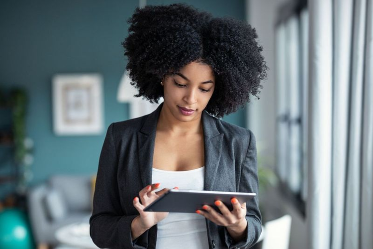 A woman looks at a memorandum of understanding on her tablet