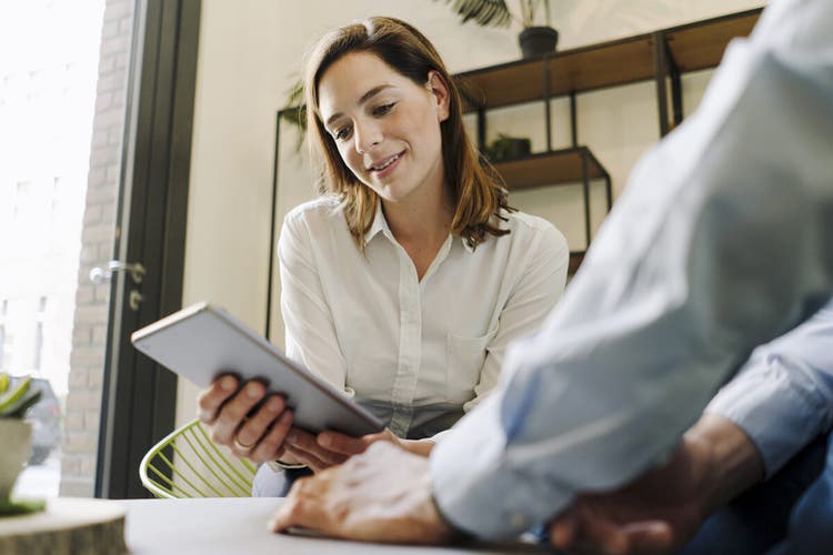 Woman in a white shirt reviewing an employment contract on a grey tablet