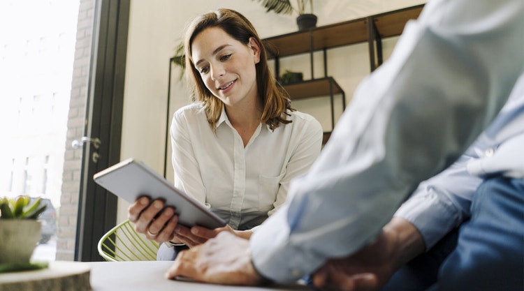 Woman in a white shirt reviewing an employment contract on a grey tablet