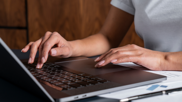 A woman types on her laptop.