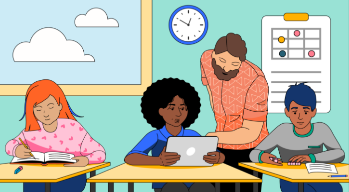 A teacher checks over a student's work in a classroom.