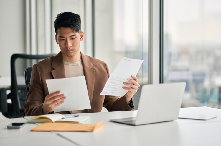 A businessman reading and reviewing tax returns in the office.