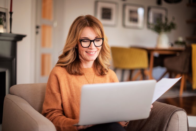 A woman researches if she needs a bill of sale in her state of residence on her laptop.