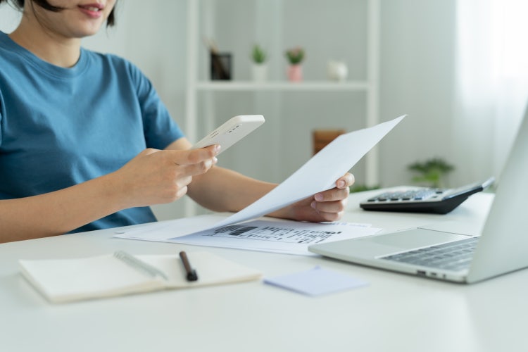 A woman uses a mobile device to convert handwriting to text using OCR for PDF