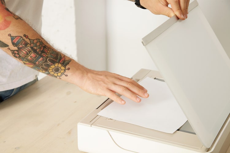 A person scans a paper using OCR to Excel spreadsheets.