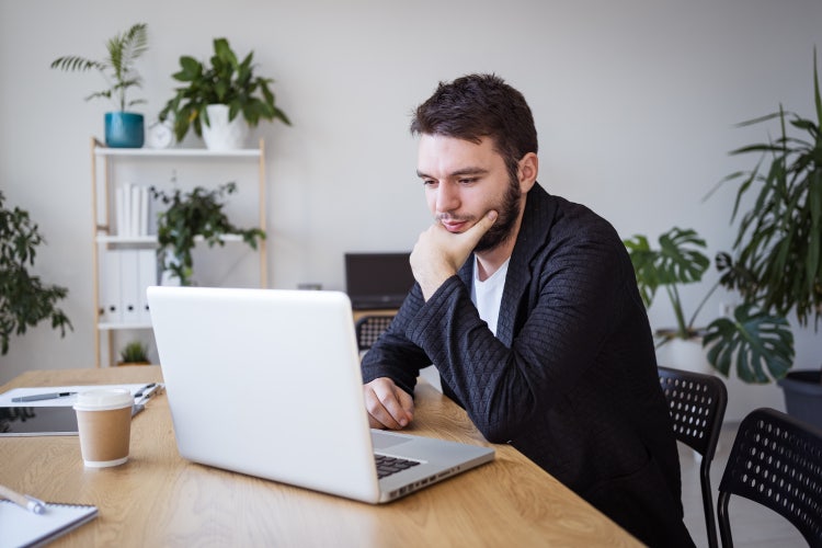 A man uses his computer to learn where to get a bill of sale form template.