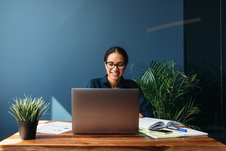 A woman duplicates a page in a Word document on a laptop.