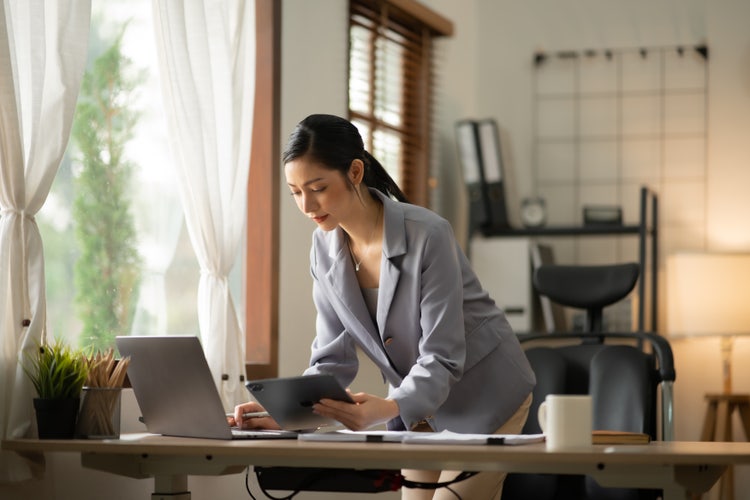 A woman syncs files between her computer and other devices.