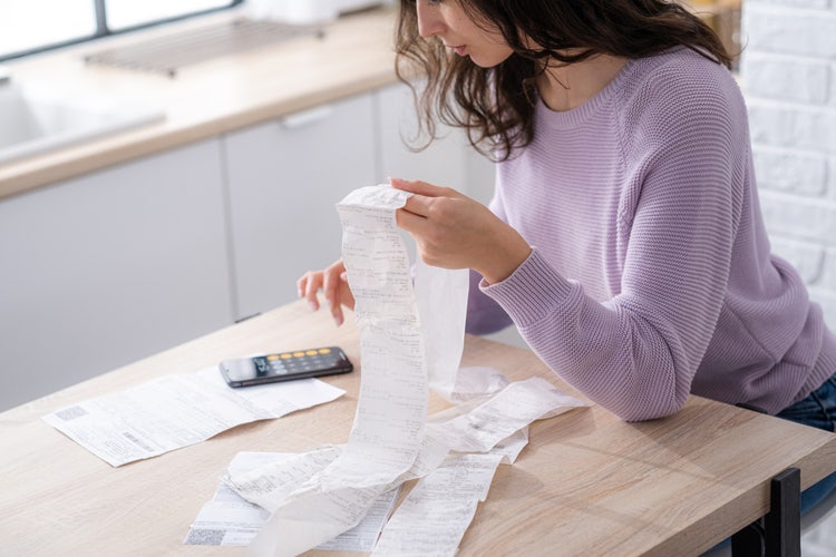 A woman sitting at a table creating a monthly budget.