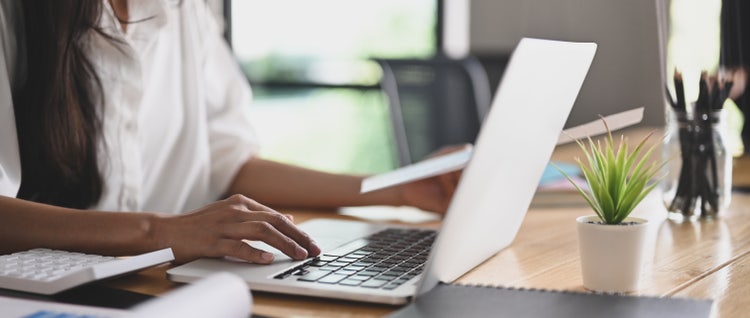 An open white laptop on a desk is used to get text from an image with OCR.