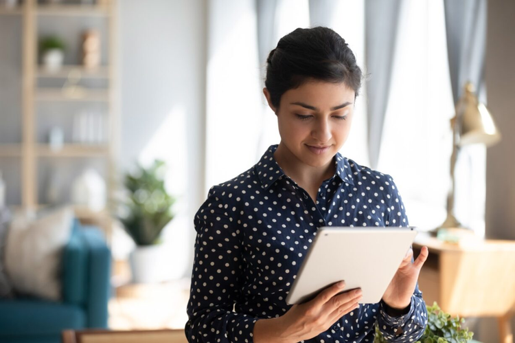 A woman uses her tablet to draw a custom e-signature.