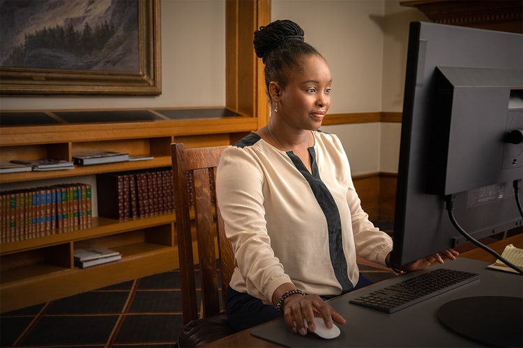 Woman in a legal office working on a computer, using an AI PDF summarizer to search for specific information.