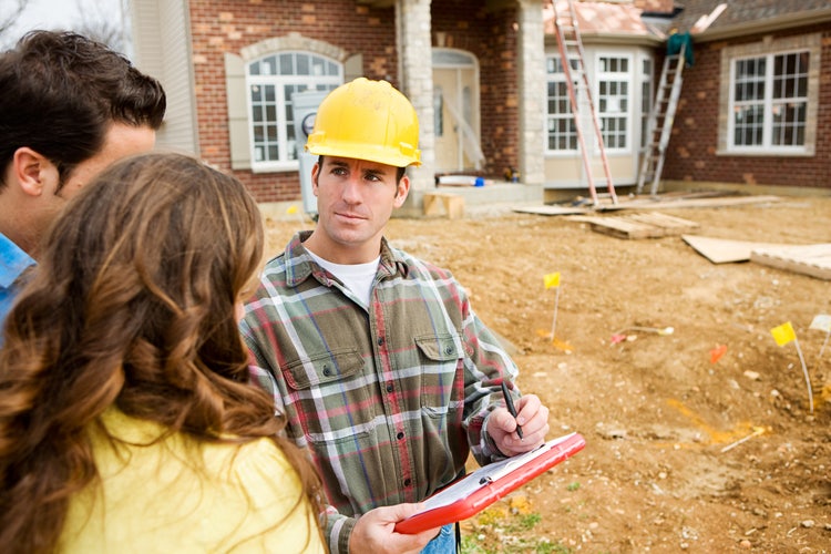 A couple goes through their new home walkthrough checklist with a builder.