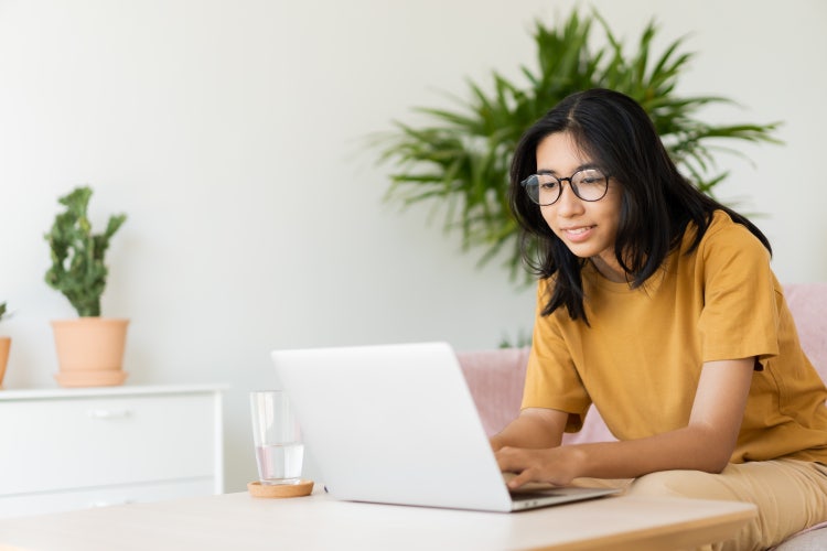 A student uses her laptop to create a college recommendation template.