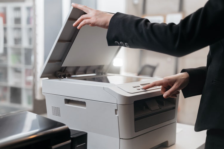 An office worker scans a book to PDF.