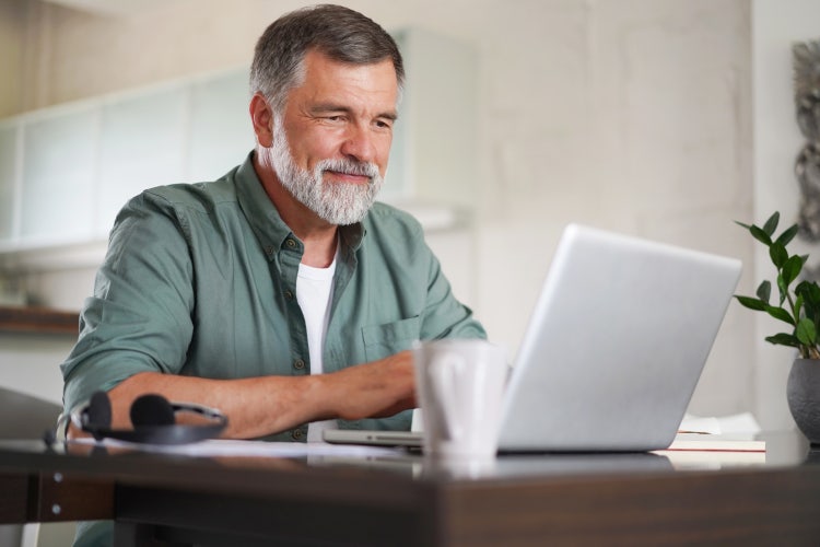 A man uses his laptop to learn how to autofill PDF forms.