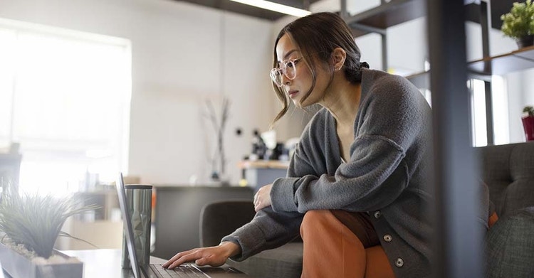 A person sitting on a couch working on digitizing important documents