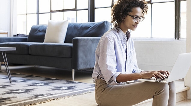 A woman wearing glasses creating a promissory note on her laptop.