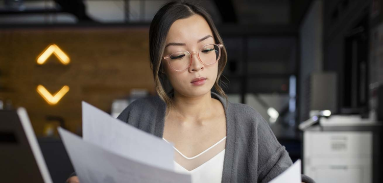 A businessperson reviewing paper copies of important documents