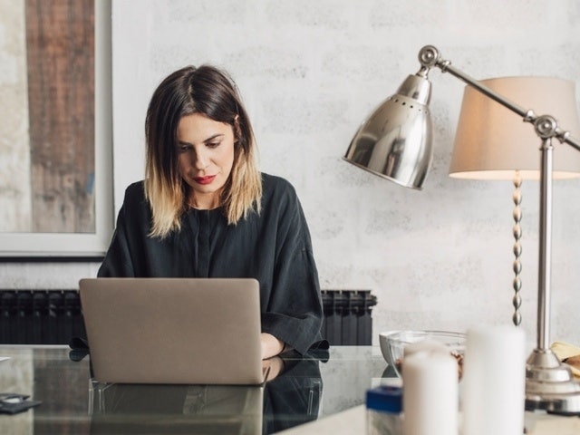 A person sitting at a glass desk working to convert JPGs to PDFs using a Mac in Adobe Acrobat