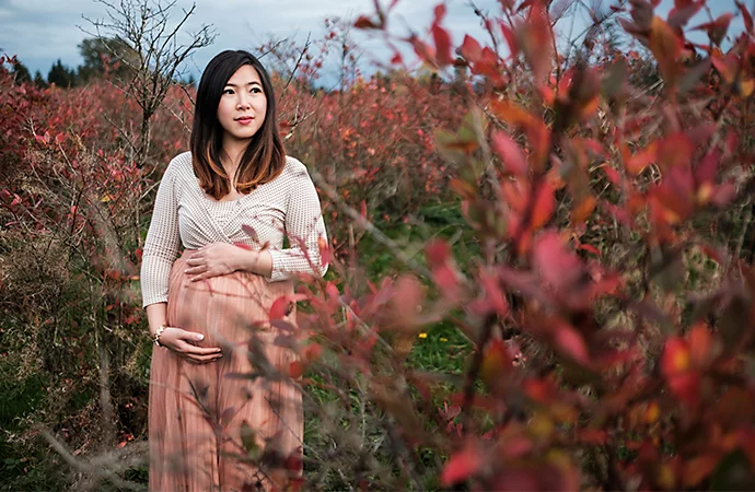 A pregnant parent posing outside for a maternity photo