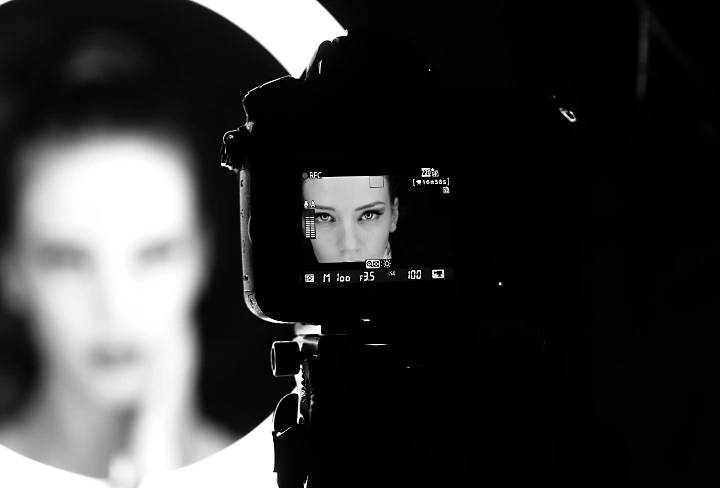 A pageant contestant seen in a camera's preview display posing for a portrait photo