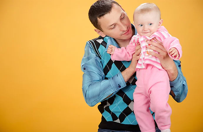 Father and daughter in a high-key lit photoshoot against a gradient yellow background