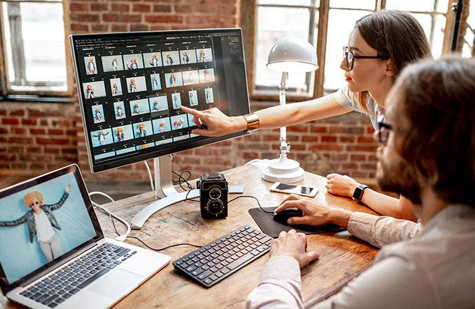 Filmmakers looking at footage on a computer in an office.