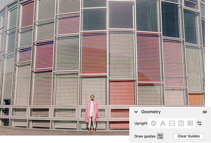 A person standing in front of a building with colorful curtains and the Adobe Photoshop Lightroom Geometry windowpane superimposed over it