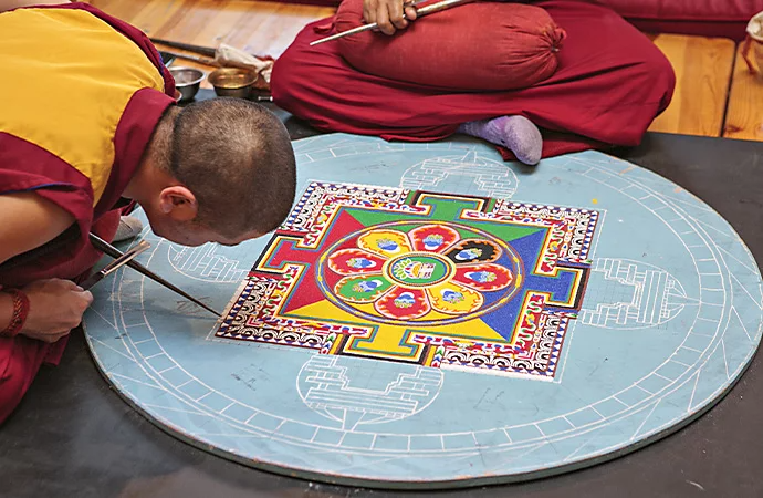 Monjes budistas creando un mandala con arena