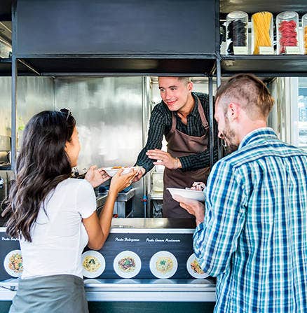 Using focal range while photographing a woman receiving food from food cart chef