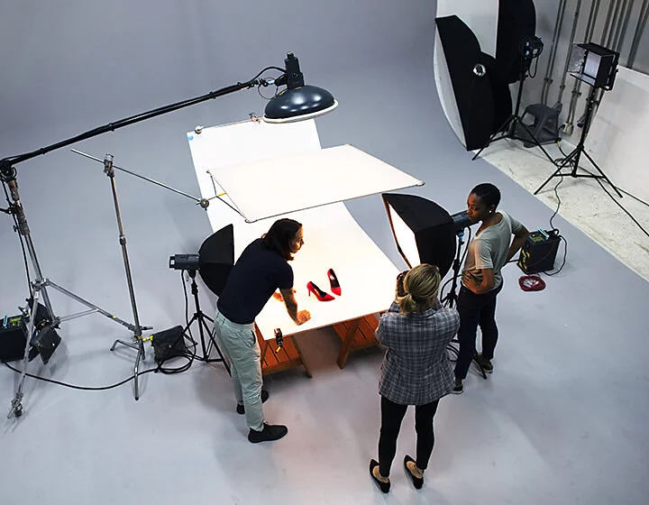 Aerial shot of product photographers staging a pair of red high heels