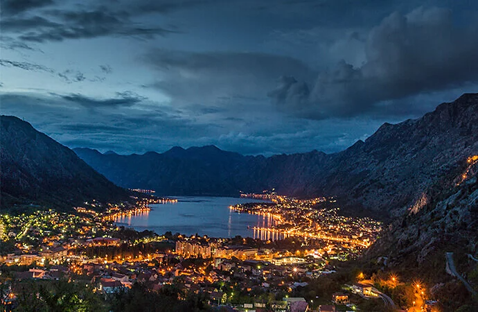 Nighttime landscape photography of a brightly lit city around a body of water