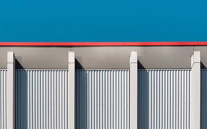 Evenly divided metal columns on the outside wall of a building creating sharp geometric angles