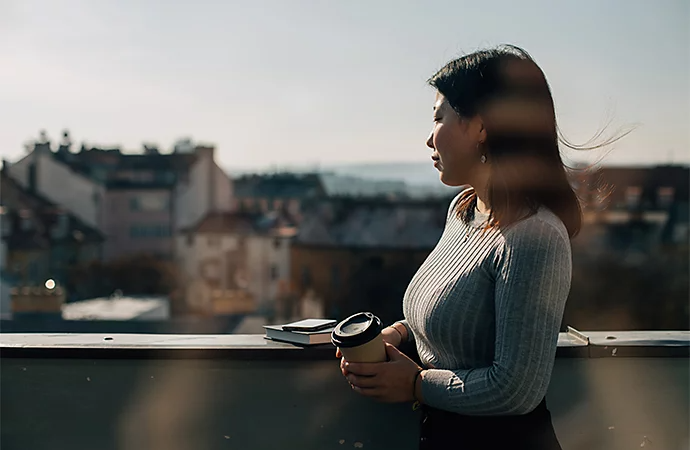 A photo of a standing person with buildings out of focus in the background displaying proper lens calibration