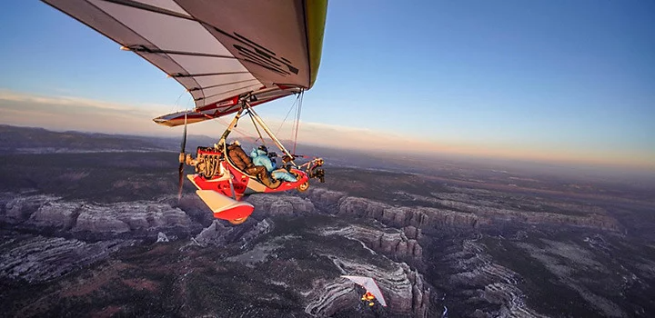 Open air trike flying high over the mountains