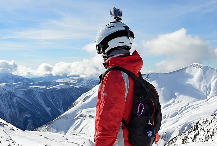 Vlogger mit GoPro-Kamera auf dem Kopf, kurz vor der Abfahrt mit Skiern