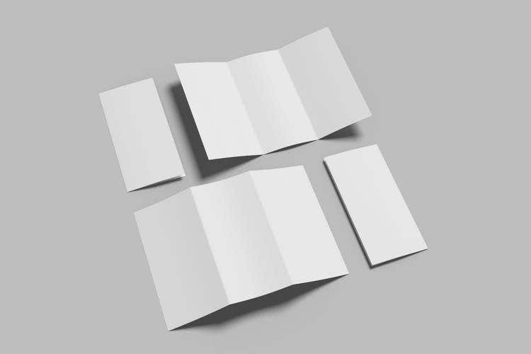 Black and white photo showing four blank pieces of paper folded into different shapes, such as a flyer, brochure, or sheet folded for mailing.