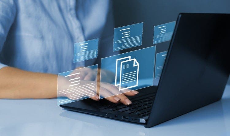 Woman working on laptop with virtual screen floating images showing document automation and management concept.