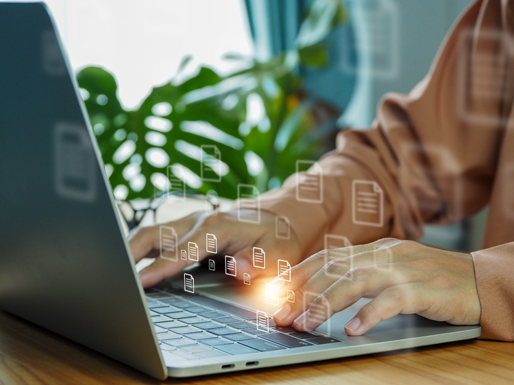 Hands and torso of a person working on a laptop. A conceptual diagram of working with multiple files is floating above the keyboard.